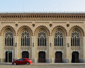 a red car parked in front of a building