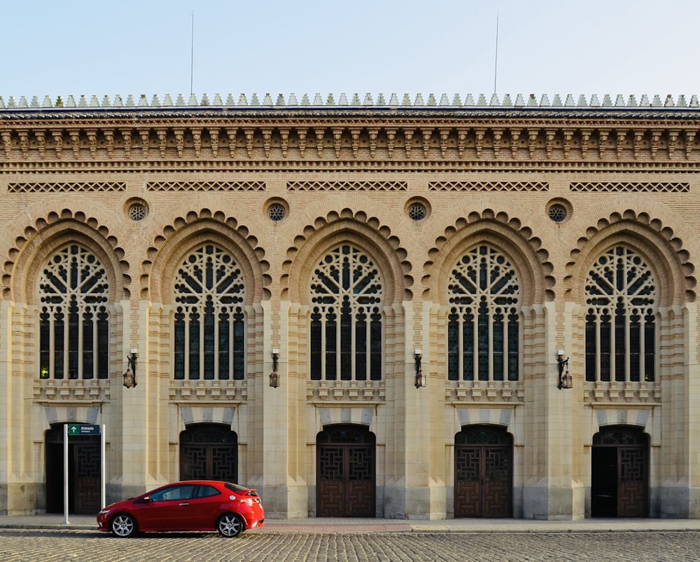 a red car parked in front of a building