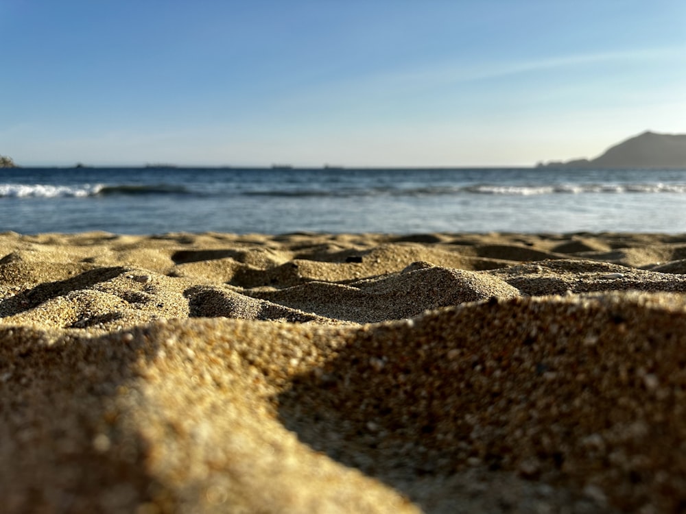 a sandy beach with waves coming in from the ocean