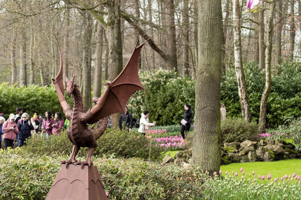 uma estátua de um dragão em um poste em um parque