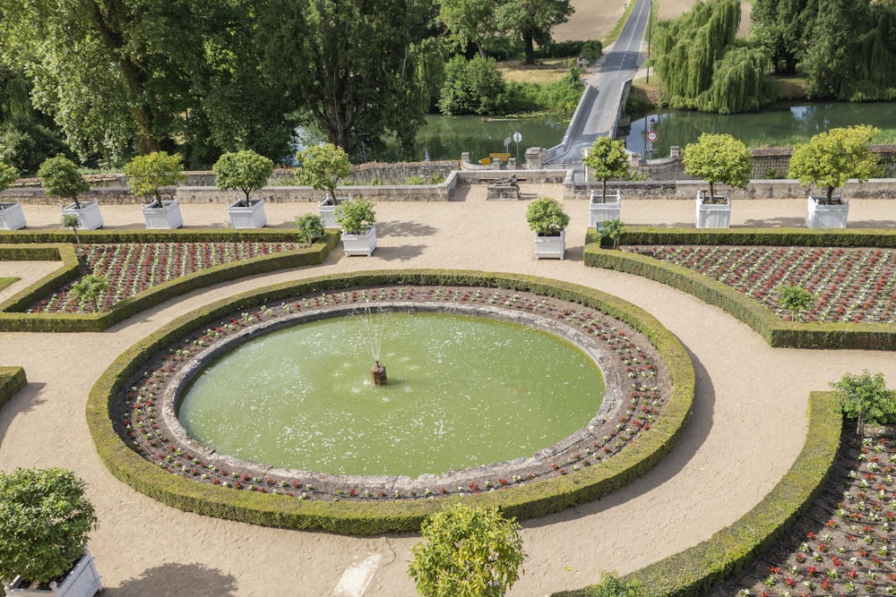 a large circular garden with a fountain in the middle of it