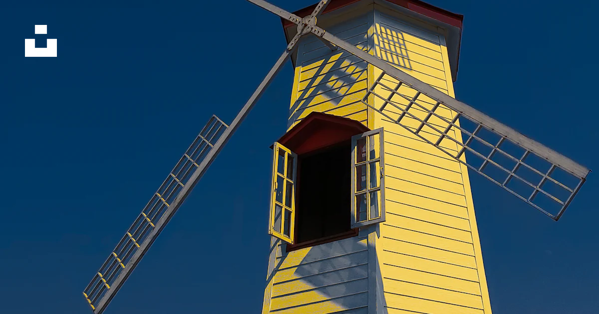 A yellow windmill with a red door and window photo – Free Blue abstract ...