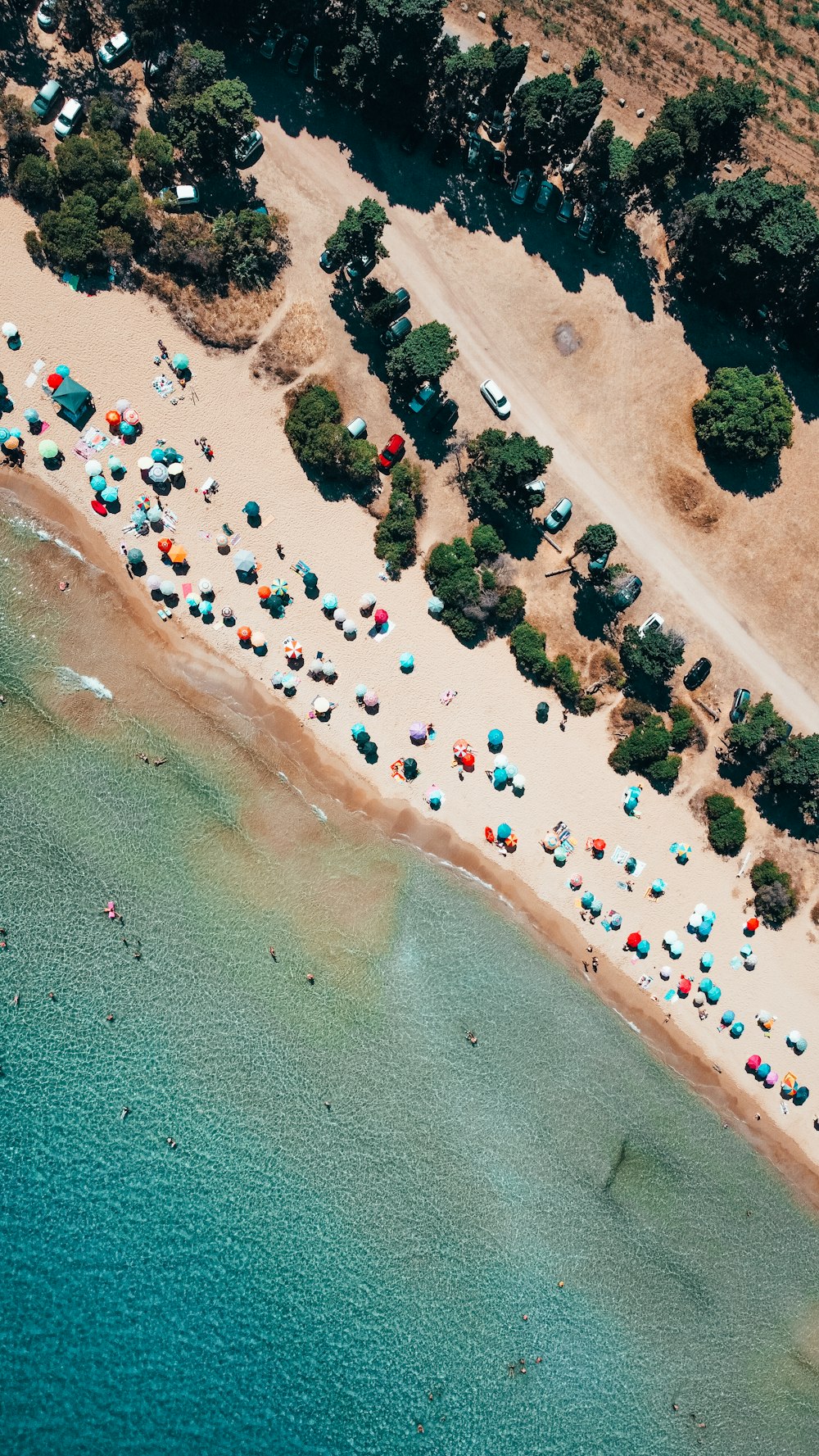 an aerial view of a beach with many umbrellas