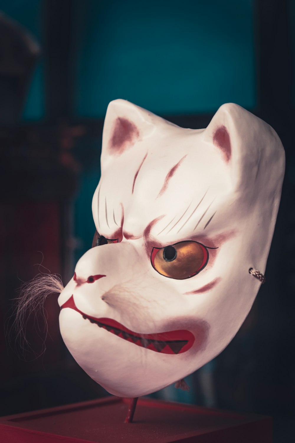 uma máscara branca com a cabeça de um gato em cima dela