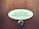A wooden door features an oval nameplate with black text displaying names, and a metal doorbell or peephole is situated below it.