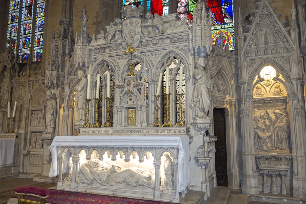 a church with a large stone alter and stained glass windows