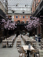 A spacious hotel dining area set for breakfast with fresh flowers.