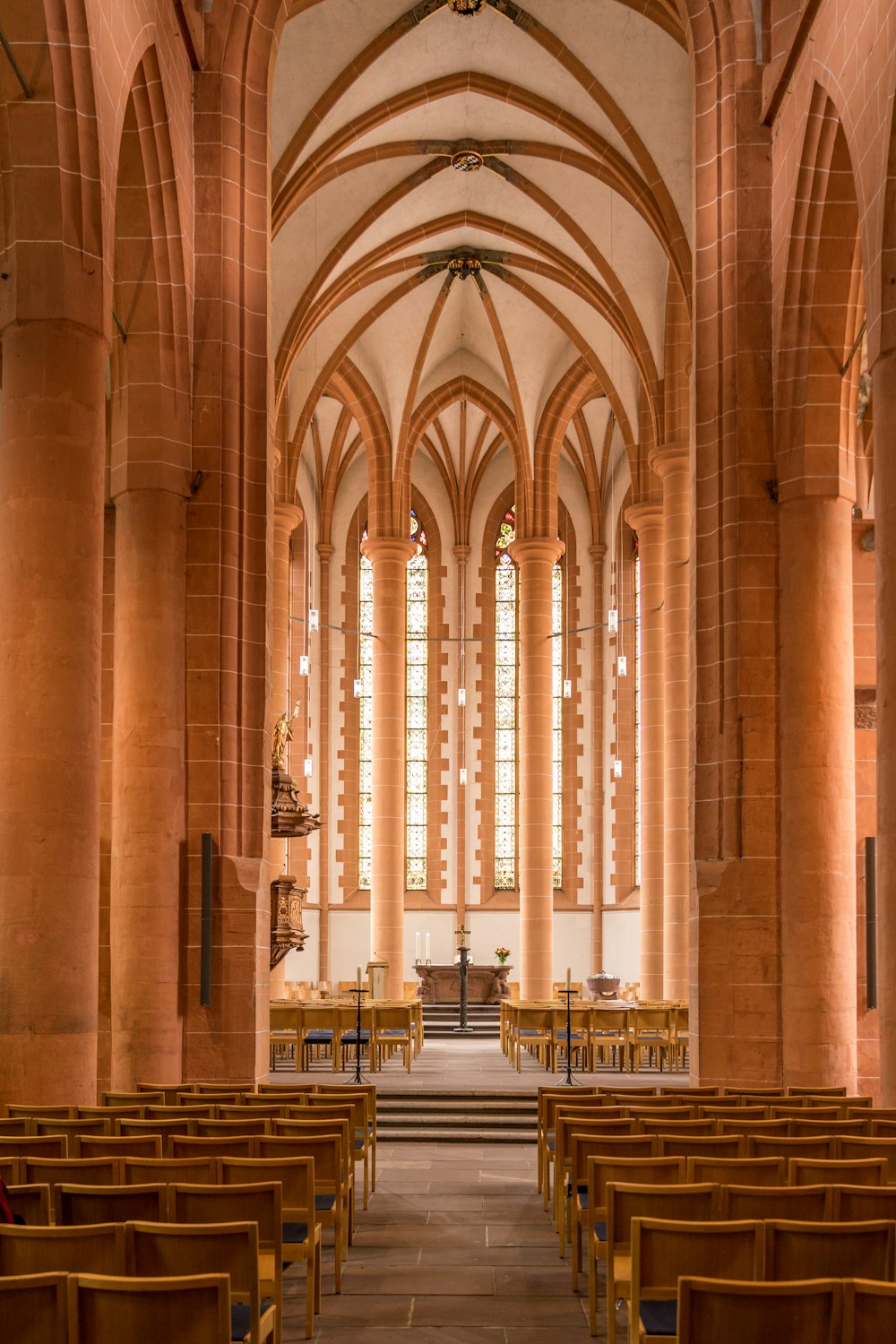 a church with rows of wooden pews and stained glass windows