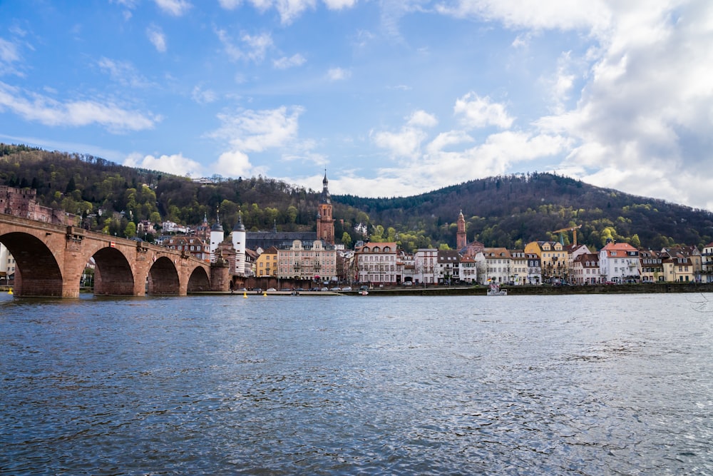 a bridge over a body of water with a city in the background