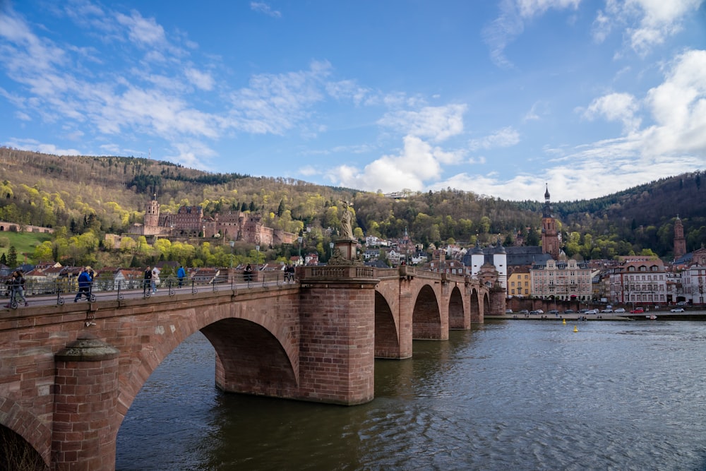 a bridge over a body of water with a city in the background