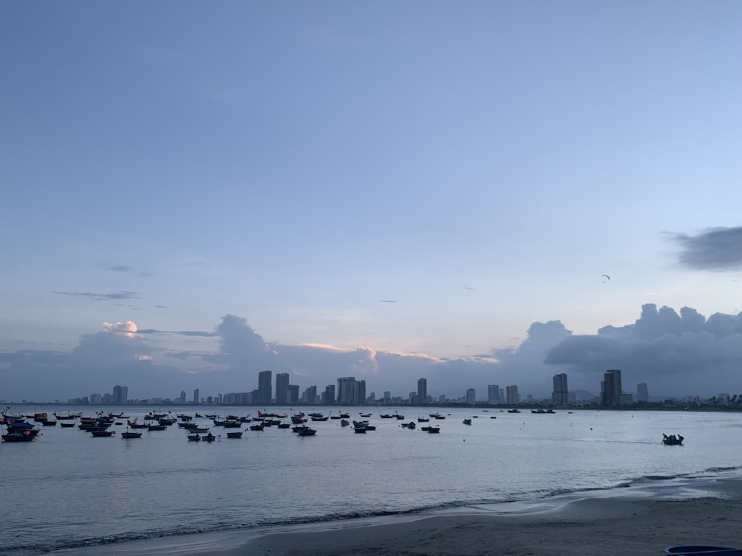 a group of boats floating on top of a body of water, Afternoon scenery viewed from Son Tra beach in Da Nang city