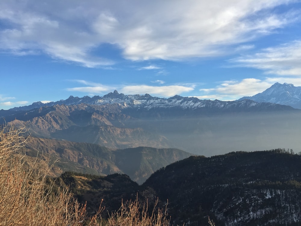 a view of a mountain range with snow capped mountains in the distance