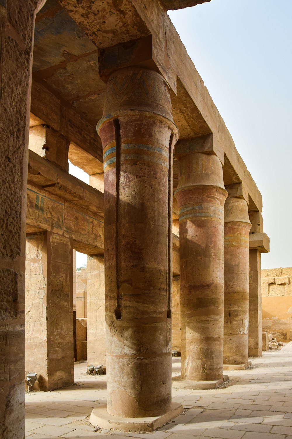 the columns of a large building with a sky in the background