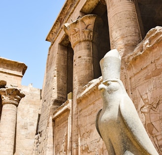 a statue of a bird in front of a building