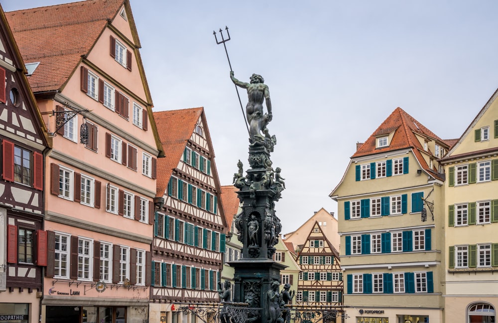 une statue au milieu d’une place de la ville