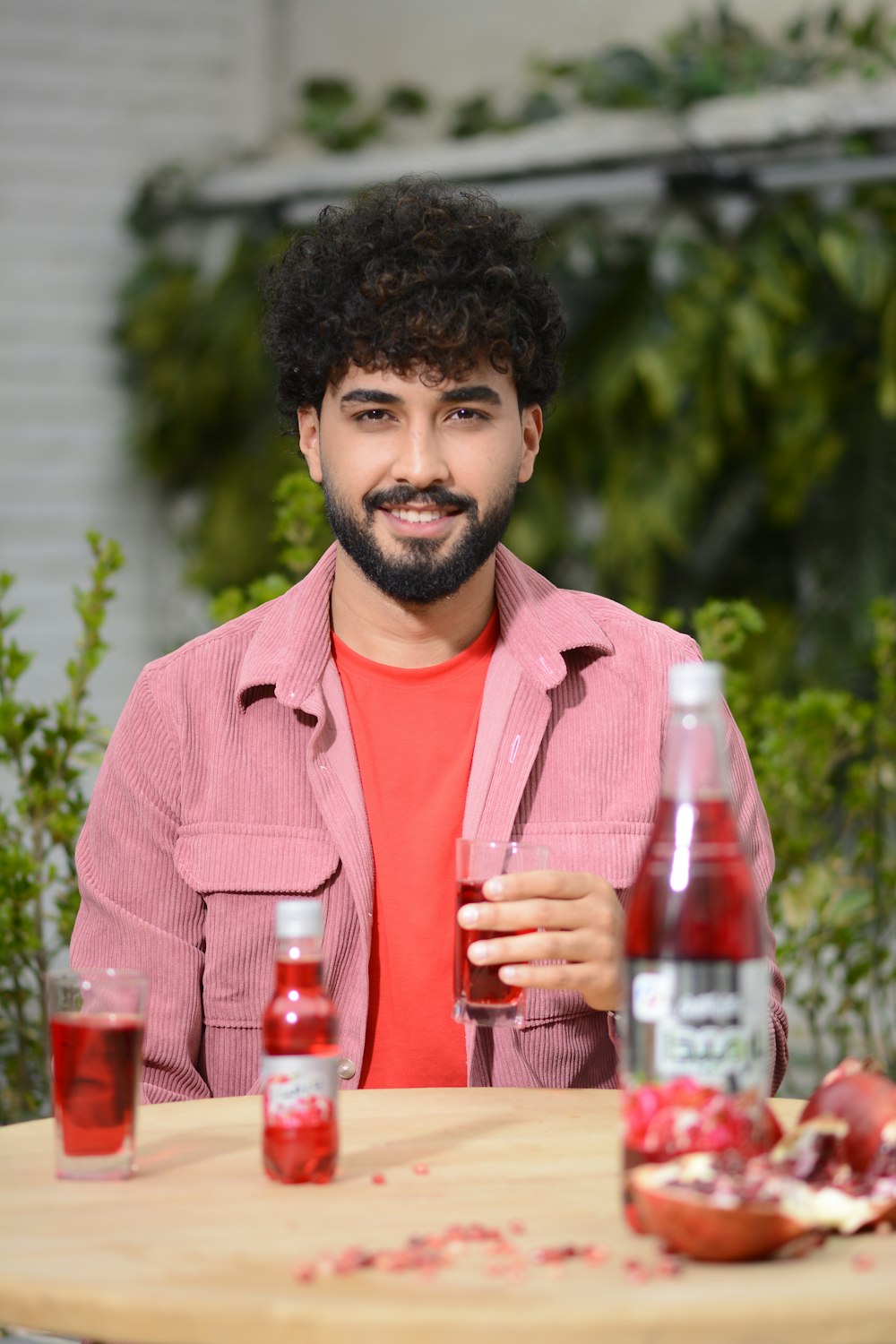 a man sitting at a table holding a glass of wine