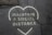 A cracked pavement features a heart-shaped outline with the words 'Maintain a Social Distance' written inside it, conveying a message of social distancing. The cracks in the pavement intersect the text, possibly signifying challenges or wear over time.