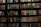 A bookshelf filled with a wide variety of books. The shelf has numerous colorful book spines, including titles in different genres such as mystery, thriller, and historical fiction. The books are neatly organized and arranged in rows, covering the entire available space on the shelf. Notable titles include 'Sea of Flames' and 'Money in the Morgue'.