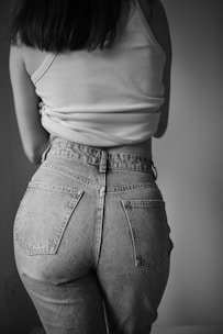 a woman in high waist jeans and a tank top