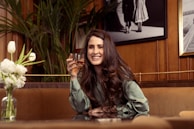a woman sitting on a couch holding a glass of wine