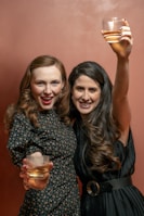 two women holding up a glass of wine