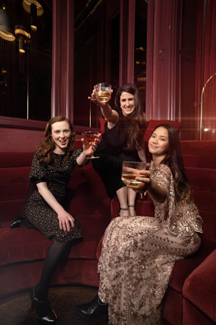 Elegant pink and gold decorated lounge with friends enjoying drinks and conversation.
