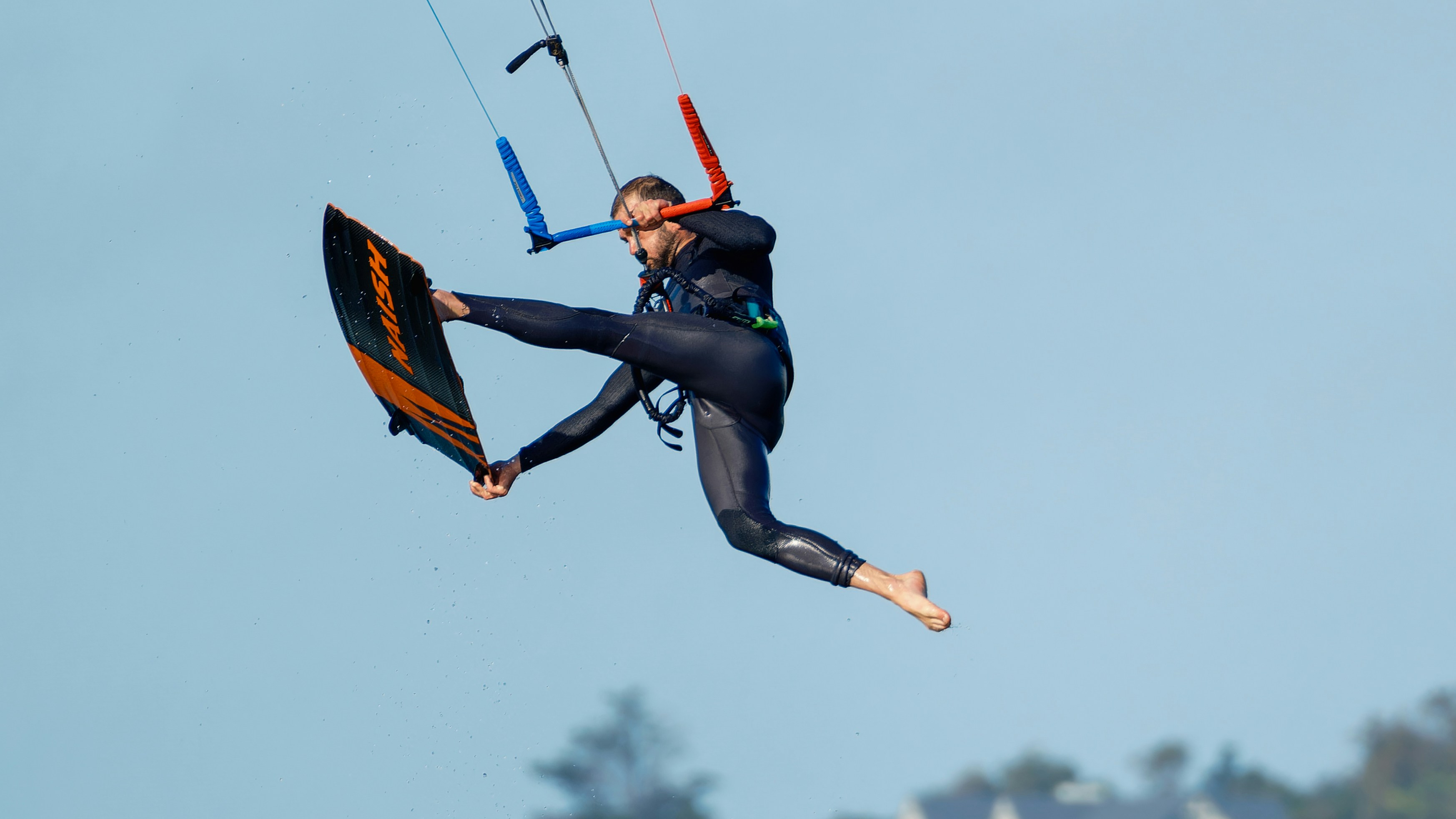 A man flying through the air while riding a kiteboard photo – Free Man ...