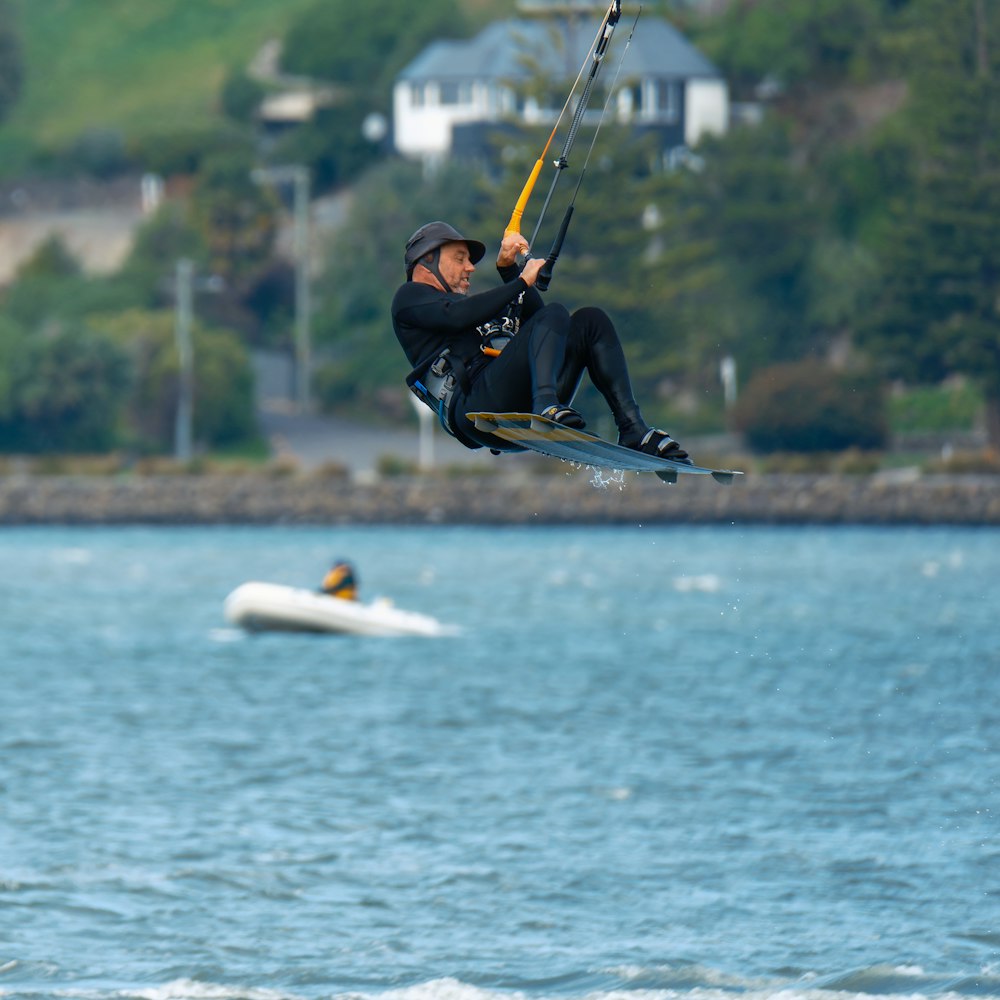 a man in a wet suit is parasailing in the water