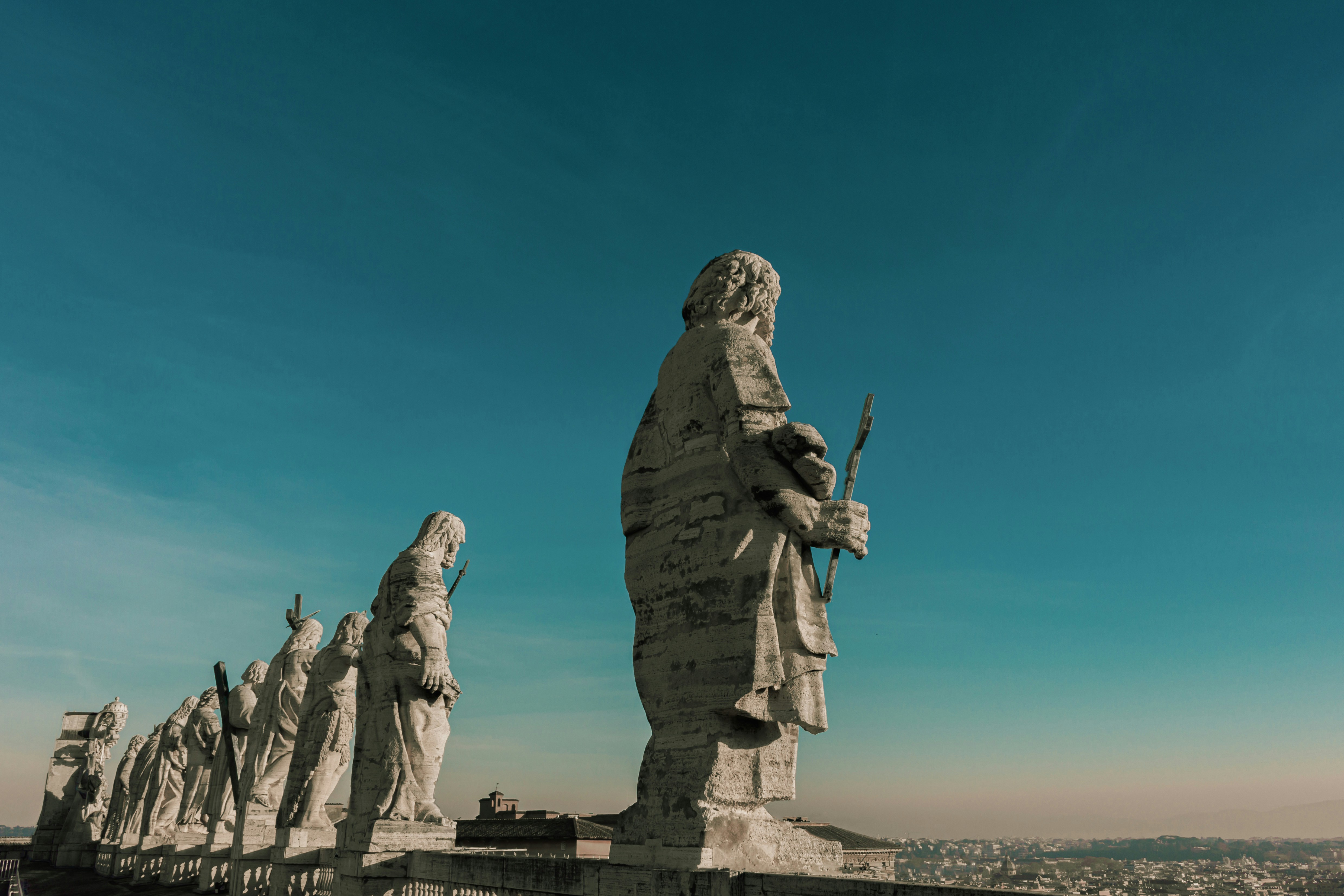 a row of statues of people holding guns