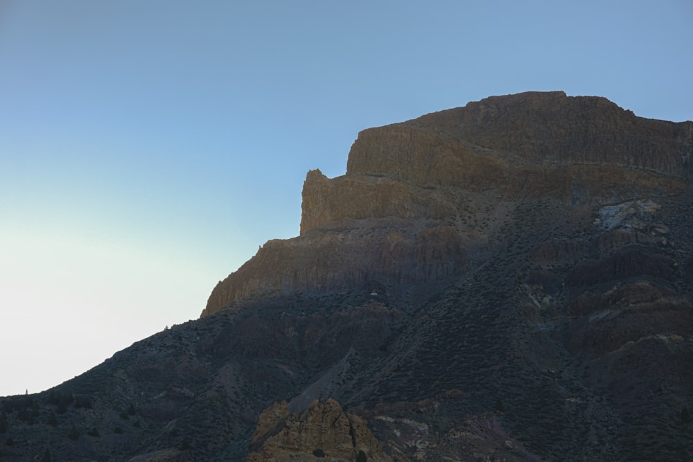 a very tall mountain with a sky in the background