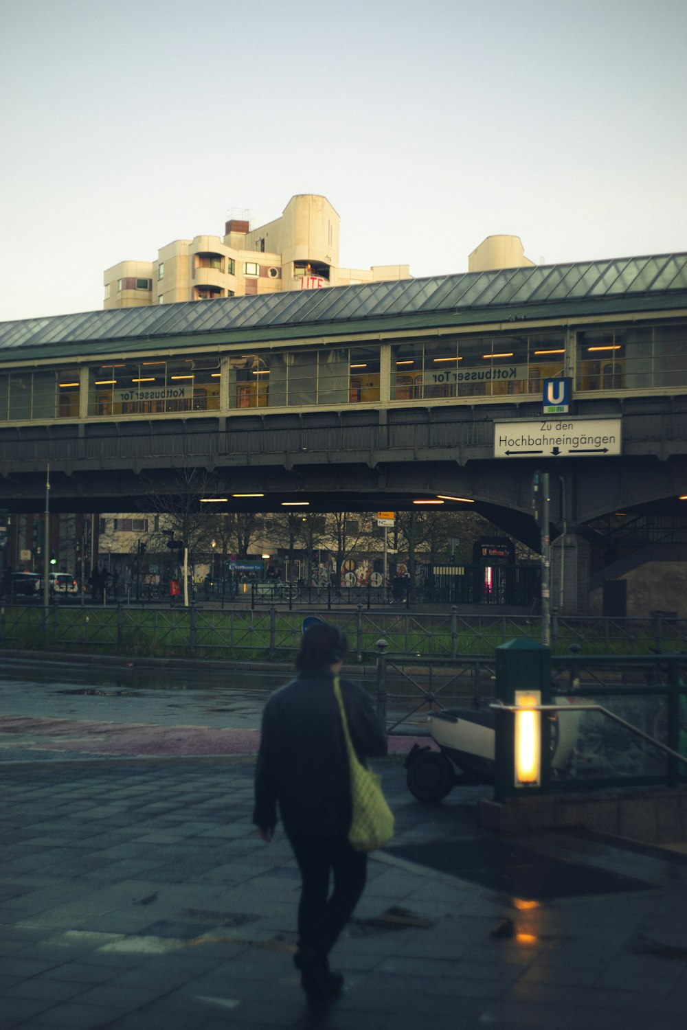 a man walking down a street in front of a train station