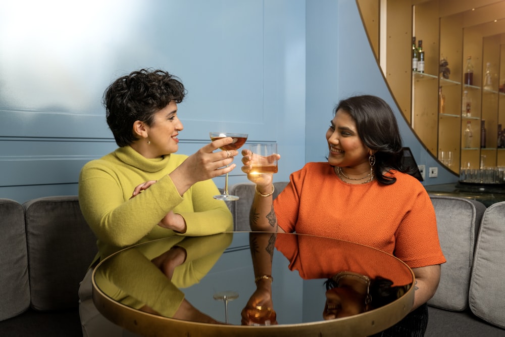 a couple of women sitting at a table drinking wine