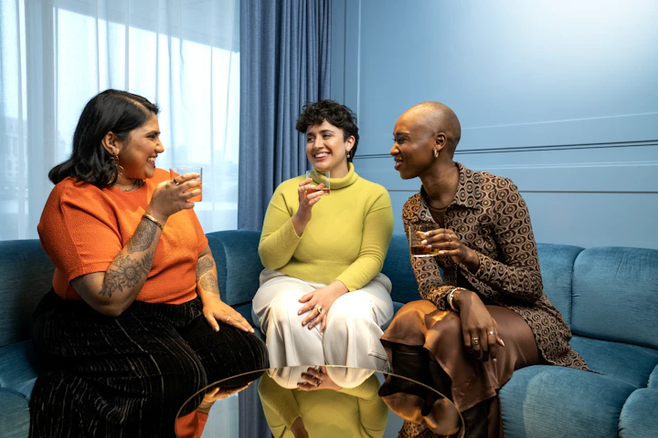 a group of women sitting on top of a blue couch