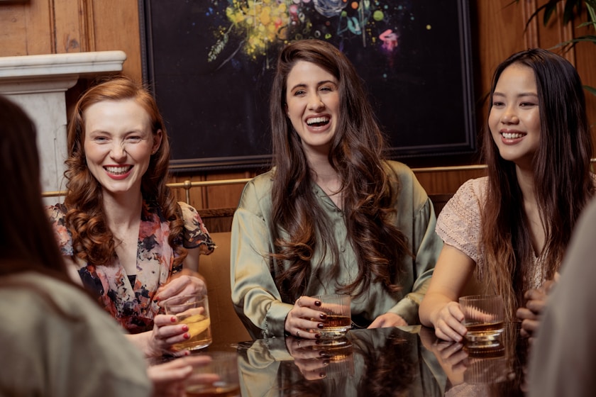 a group of women sitting around a table with drinks