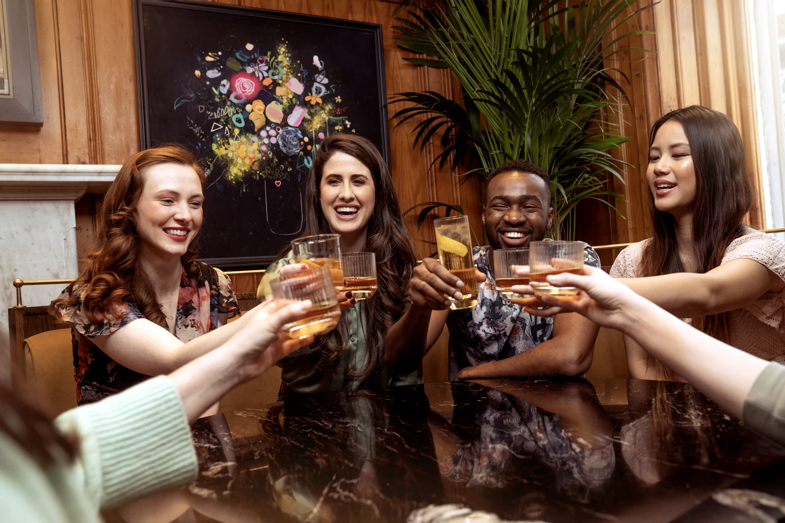 Friends raising their glasses for a toast at a bar