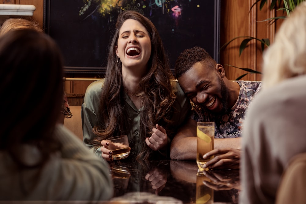 a group of people sitting around a table laughing