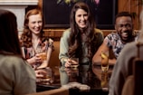 A lively pub scene with friends laughing around a trivia table.