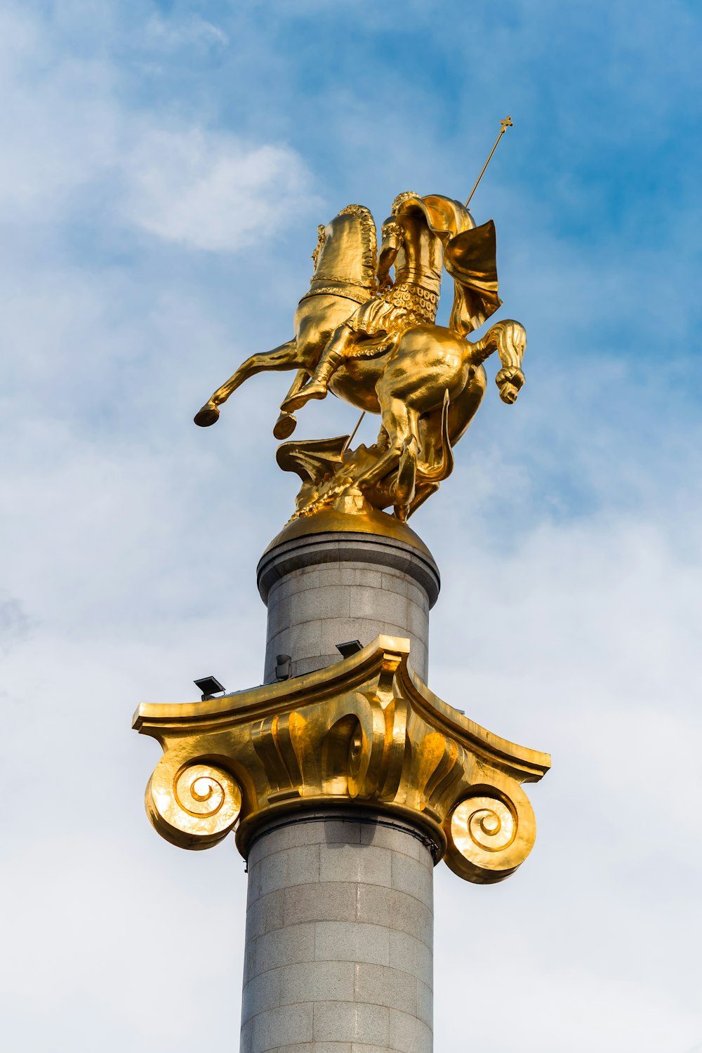 a statue of a man riding a horse on top of a pillar