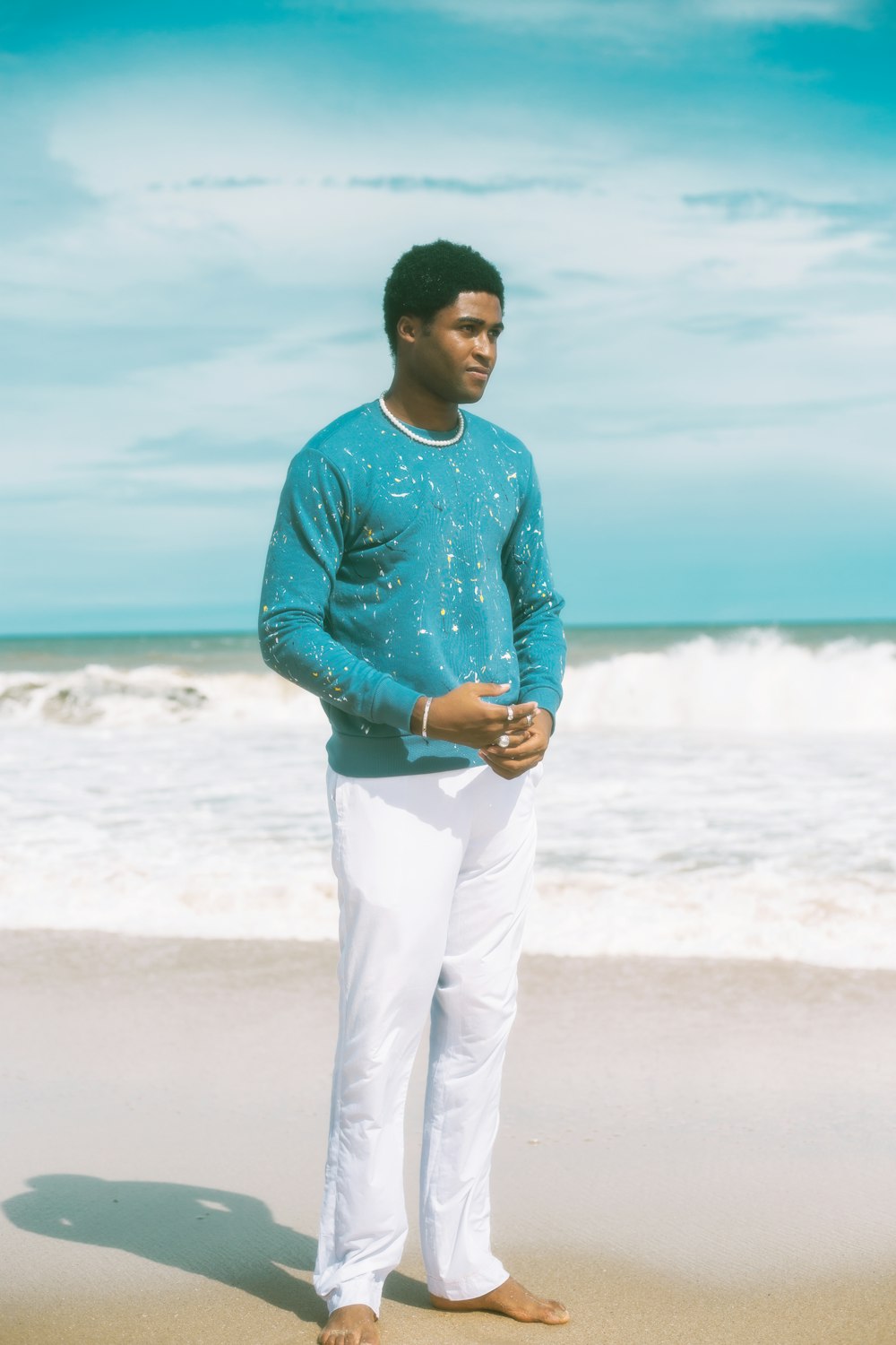 a man standing on a beach next to the ocean