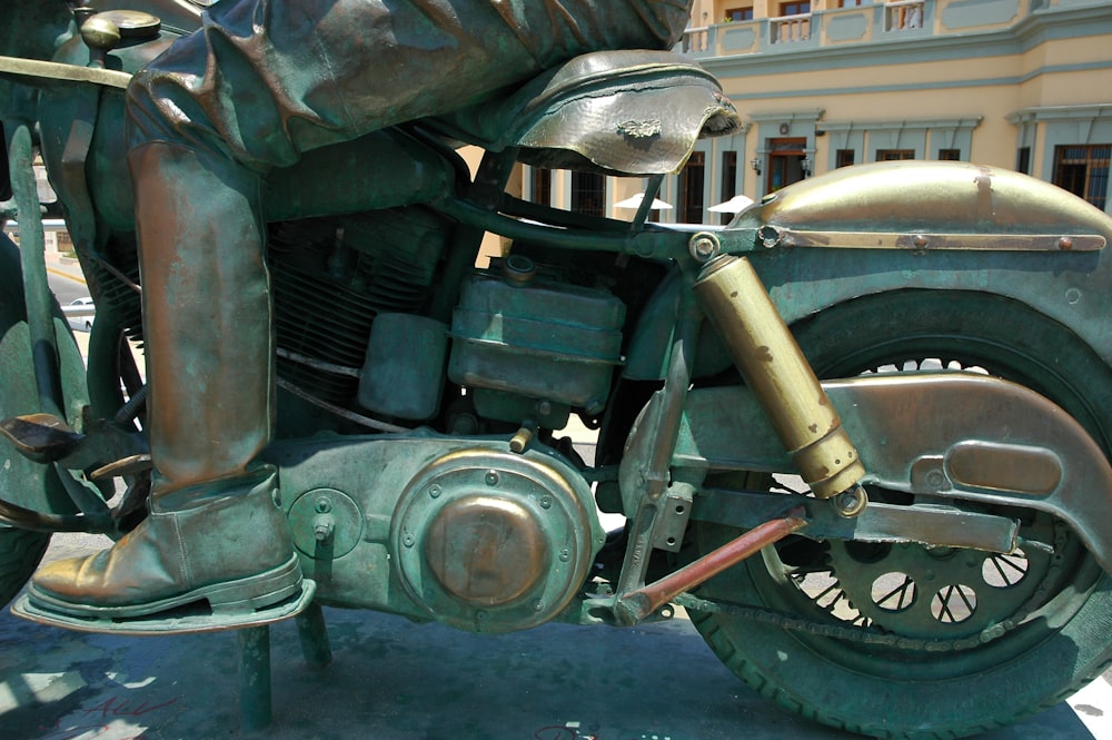 a bronze statue of a man riding a motorcycle