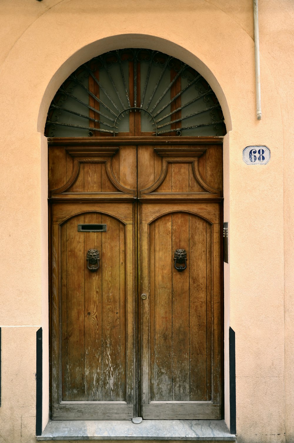 a large wooden door with a clock on the side of it