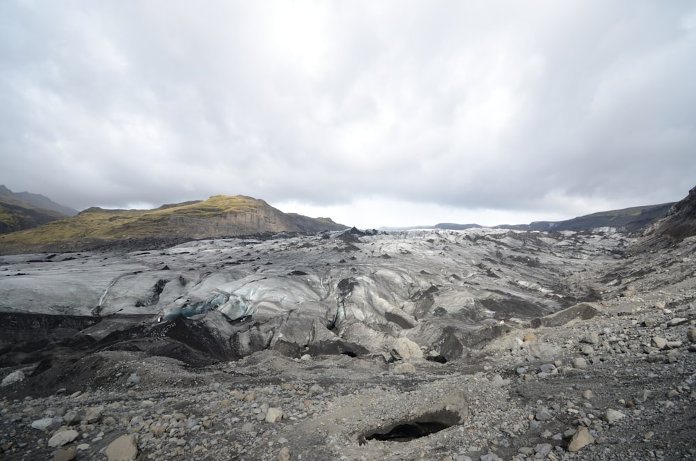 a rocky landscape with a glacier in the distance