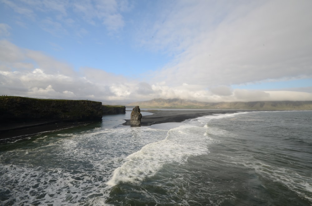 a large body of water next to a rocky cliff