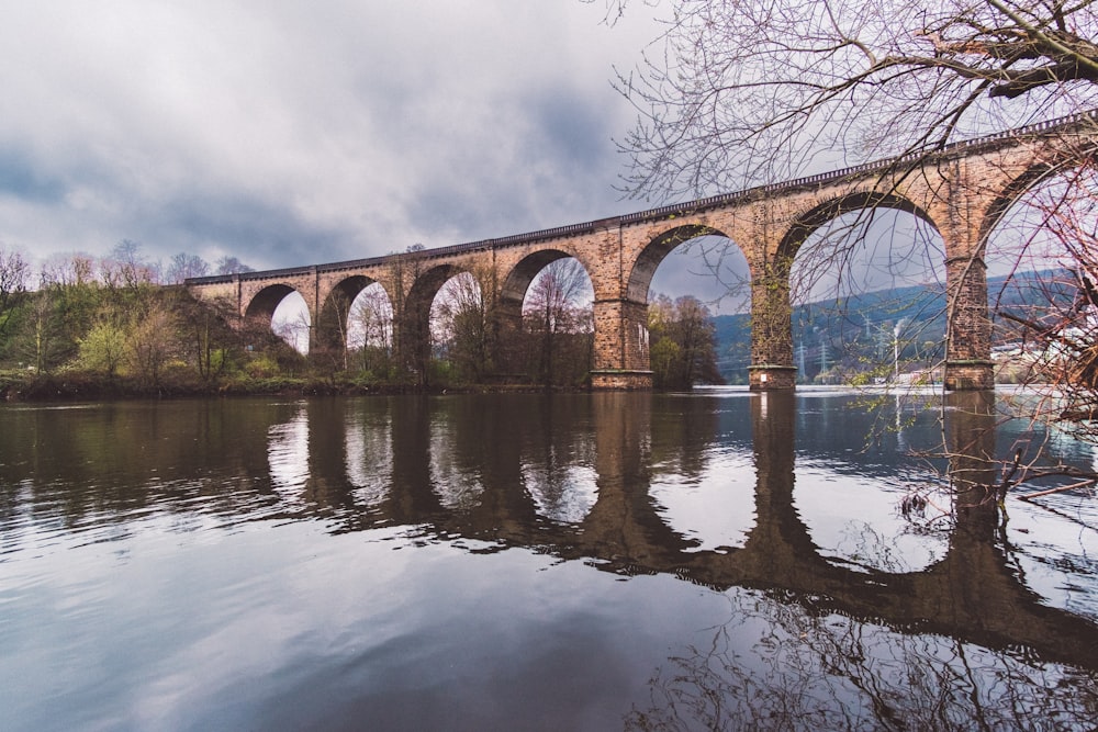 a bridge over a body of water under a cloudy sky