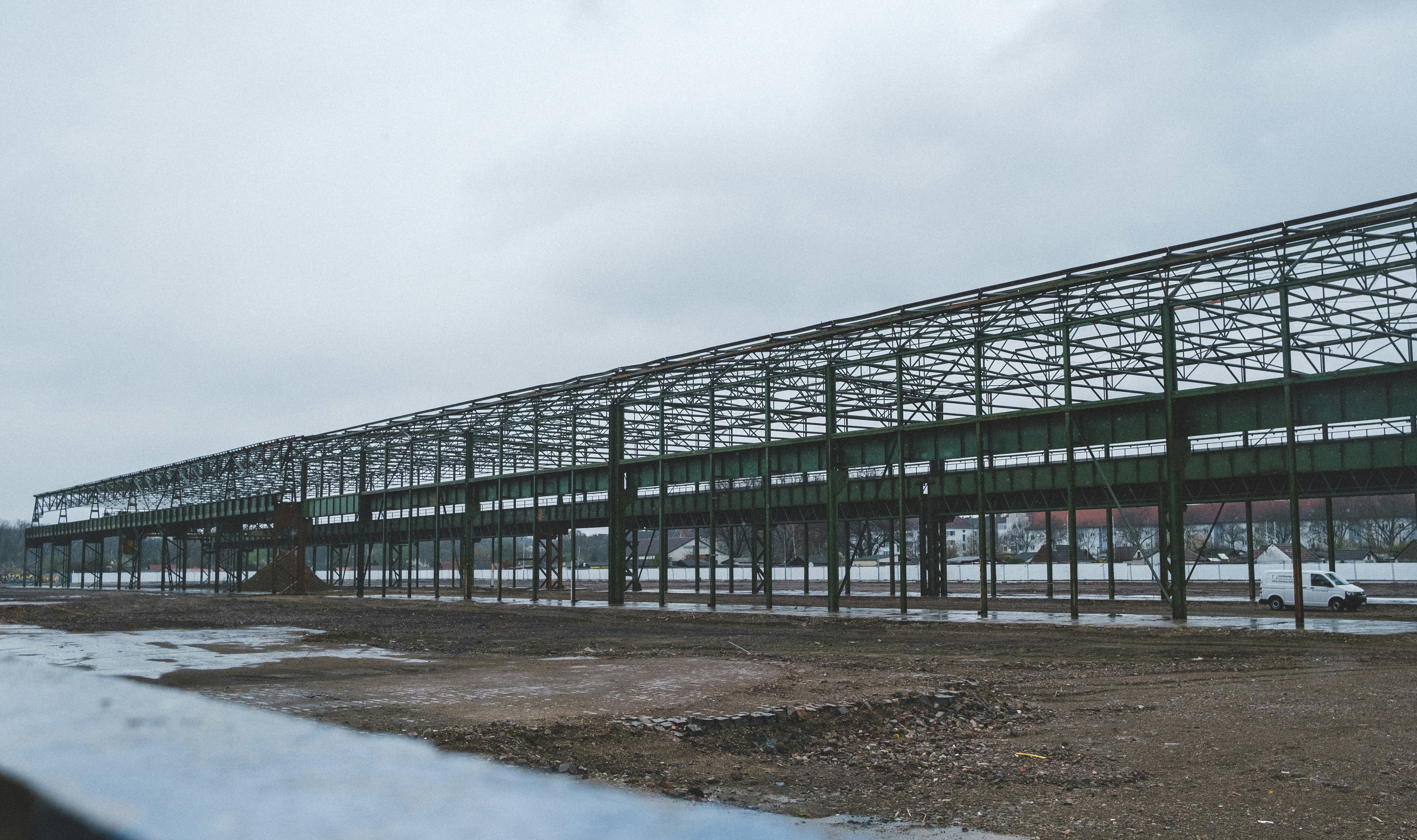 a large metal structure sitting on top of a dirt field