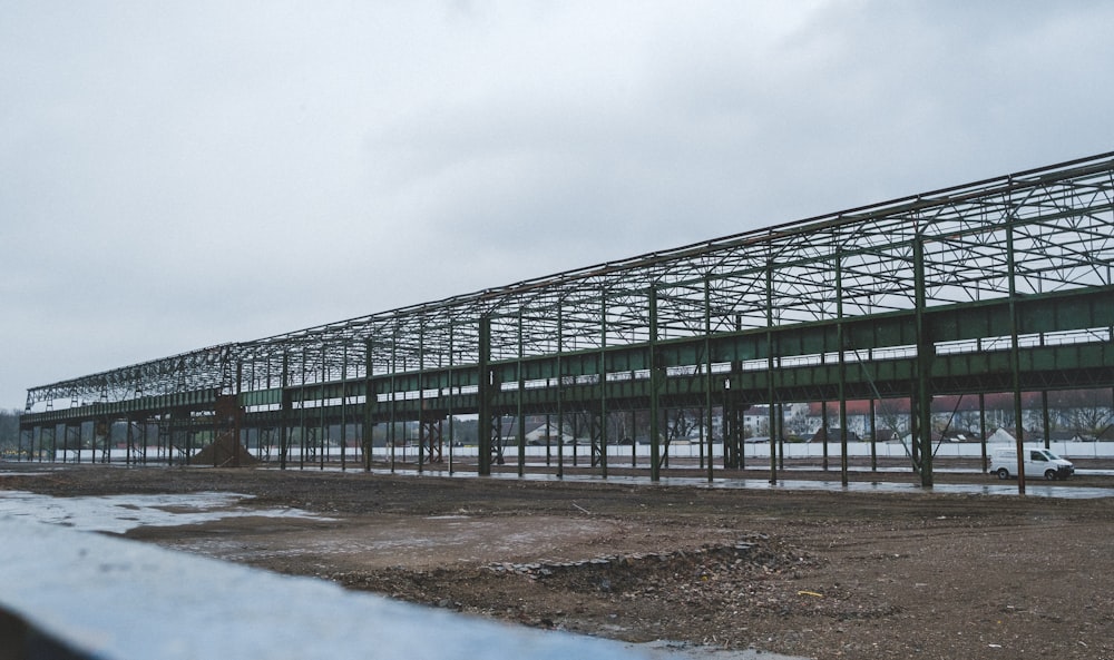 a large metal structure sitting on top of a dirt field