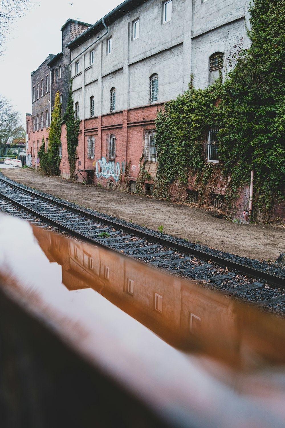 a train track next to a building with graffiti on it