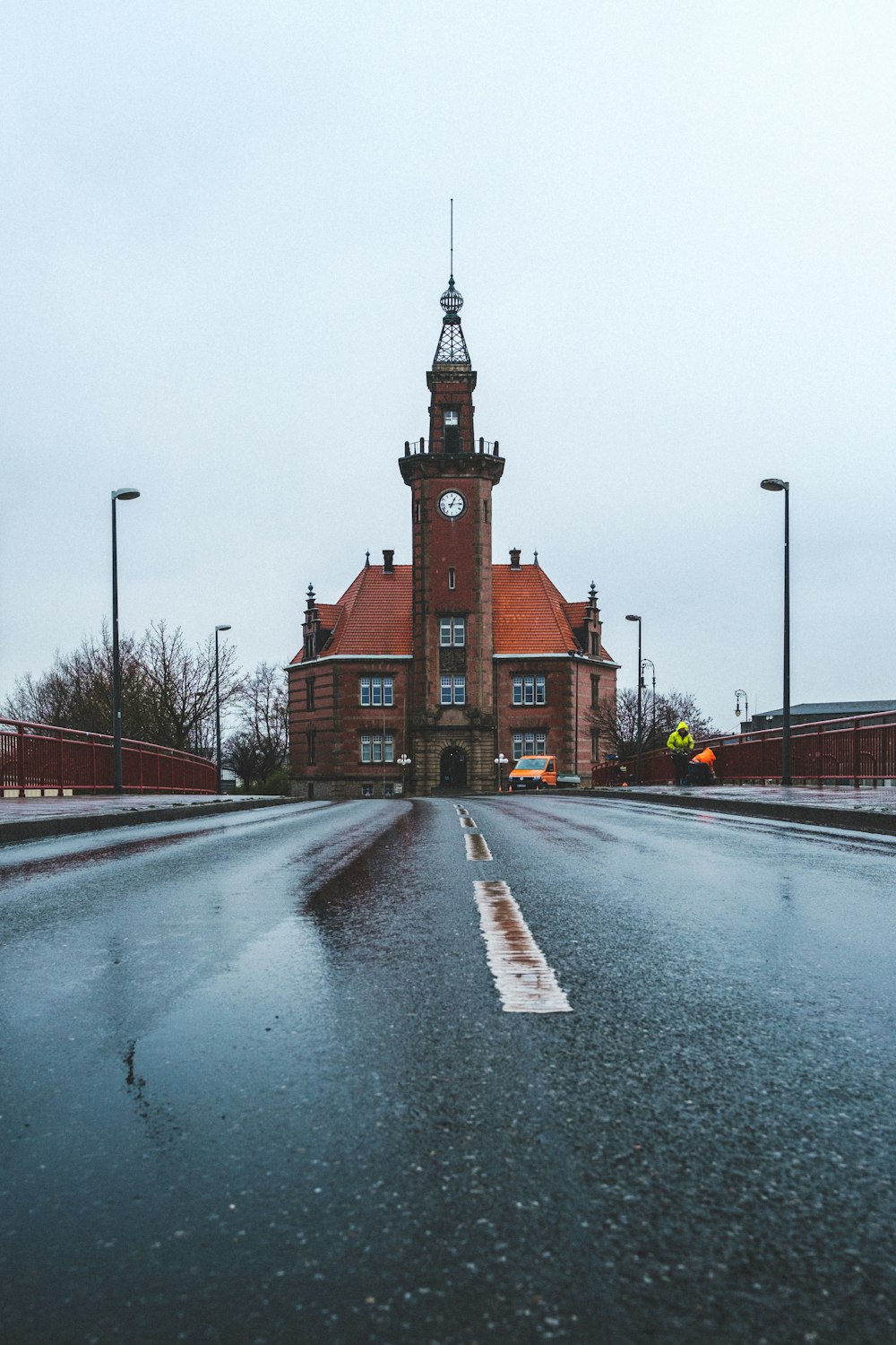 Une rue humide avec une tour de l’horloge en arrière-plan