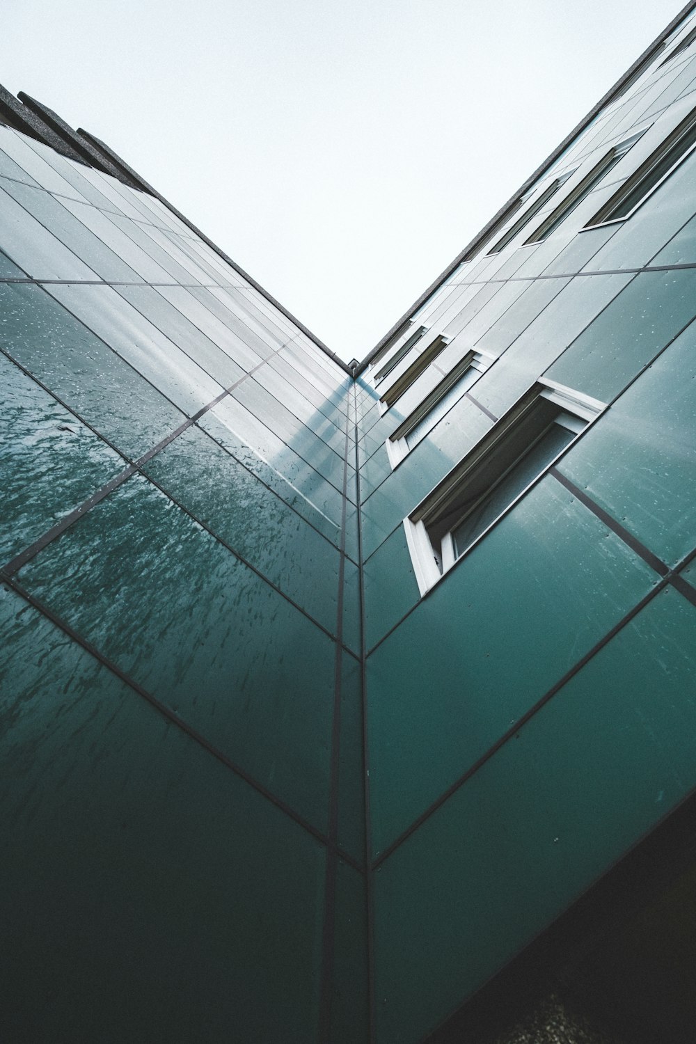 the corner of a building with a window and sky in the background