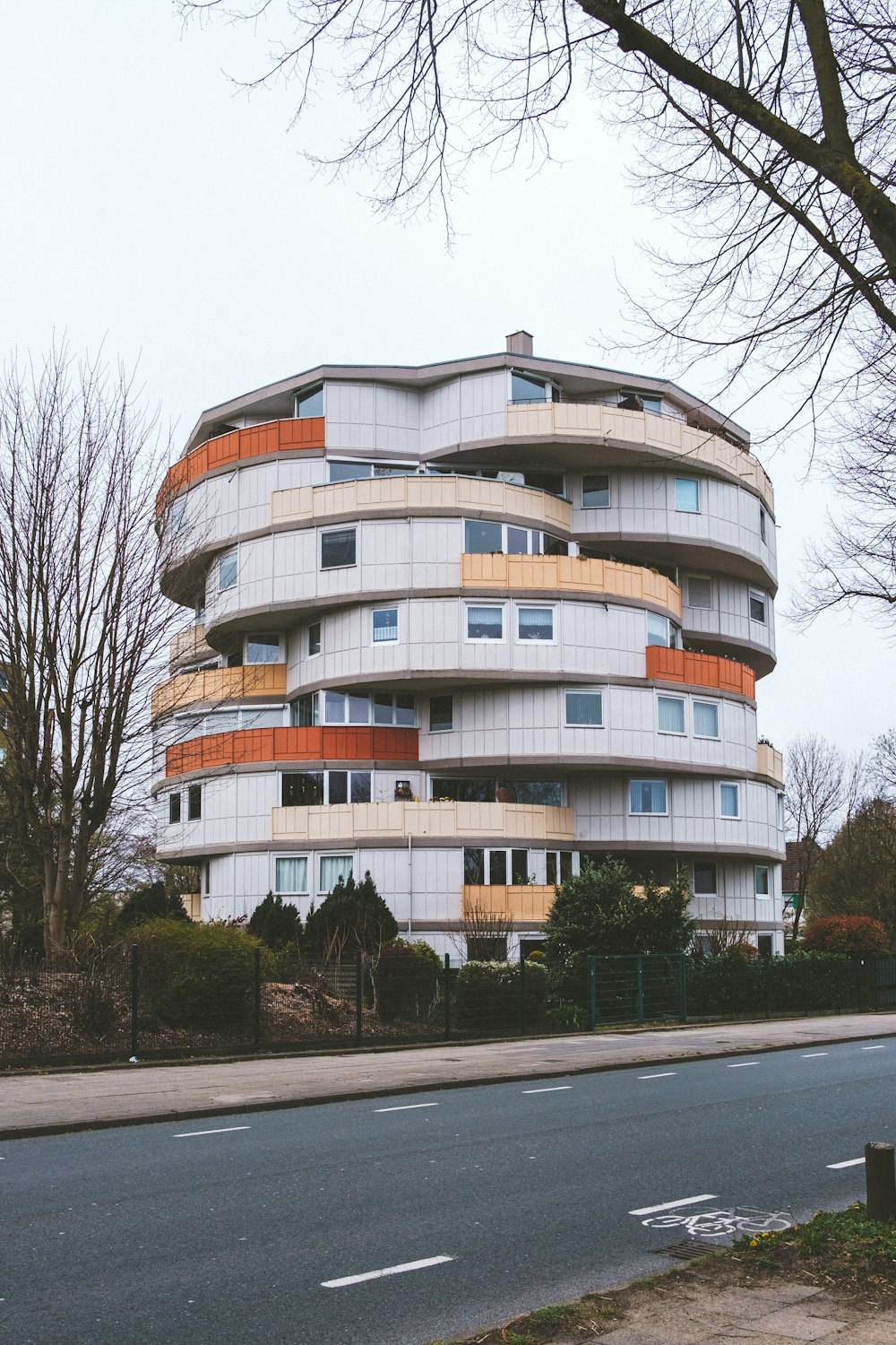 a tall building with a circular balcony next to a street